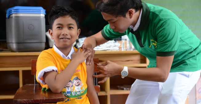 image of child in school getting dengue vaccine