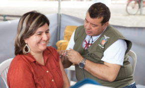 Dengvaxia rollout in Brazil: Image of a woman getting vaccinated against dengue fever.