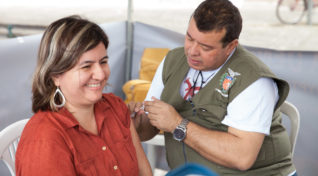 Image of a woman getting a dengue vaccine in Parana's dengue immunization program.