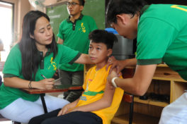 Image of a student getting vaccinated against dengue in the Philippines' dengue vaccination program.