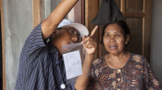 Image from one of the Wolbachia programs in Asia of a woman in Indonesia being shown the variety of mosquitoes caught during a monitoring program.